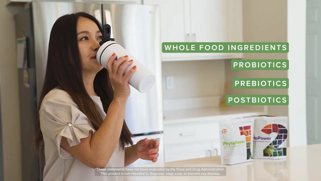 Een persoon die een supplementenshake drinkt in een keuken met productzakken op het aanrecht en groene opschriften met Whole Food-ingrediënten, probiotica, prebiotica, postbiotica.